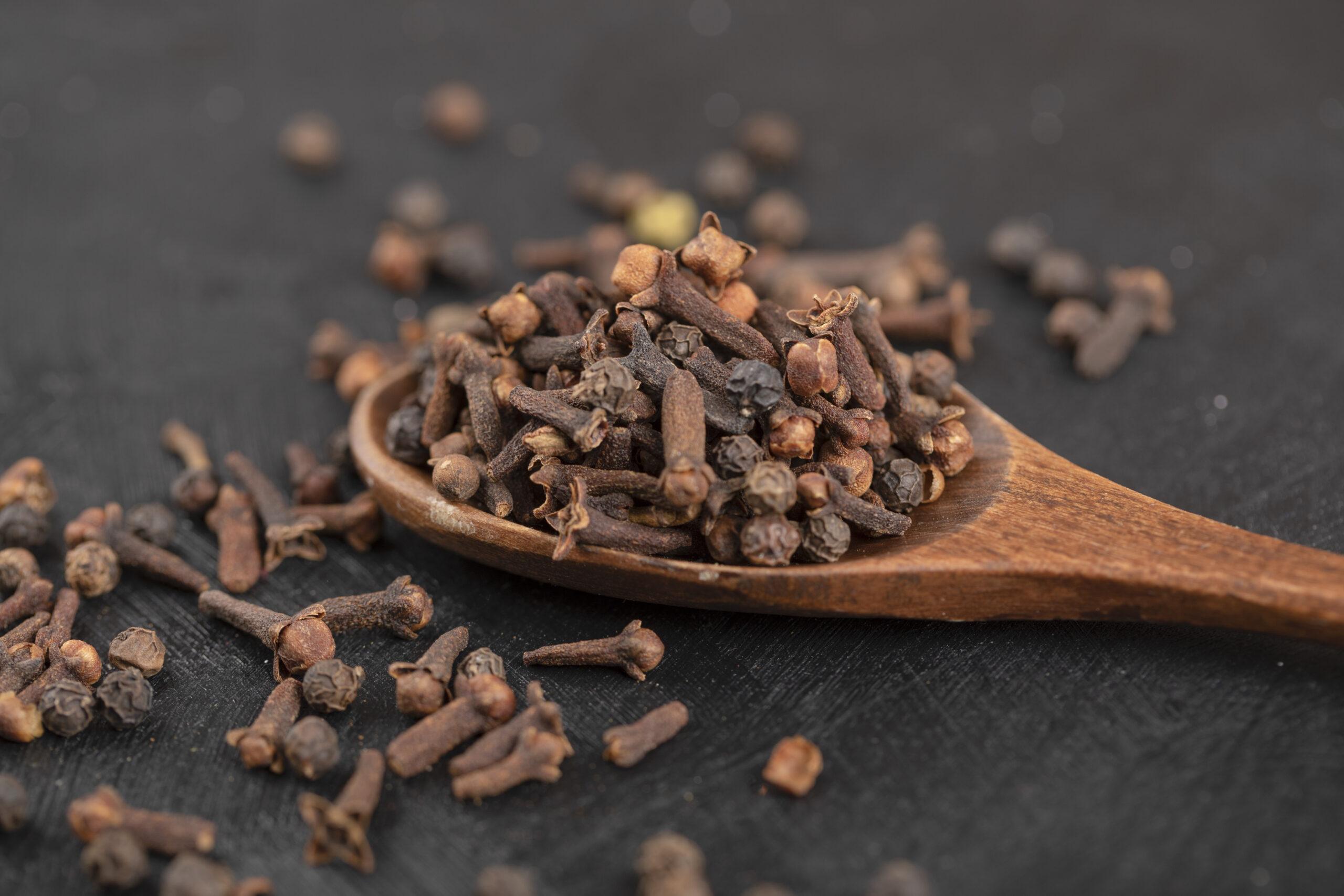 Dried cloves in a wooden spoon showcasing health benefits